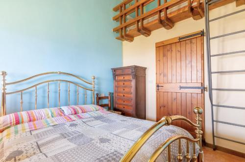 een slaapkamer met een bed en een houten deur bij La Loggia in Pian di Scò