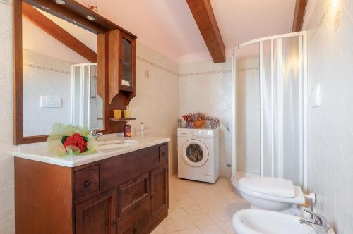 een badkamer met een wastafel en een wasmachine bij La Loggia in Pian di Scò