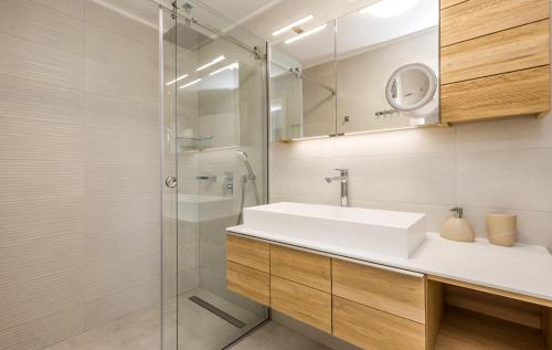 W łazience znajduje się umywalka i przeszklony prysznic. w obiekcie Villa Sunrise w mieście Lopar