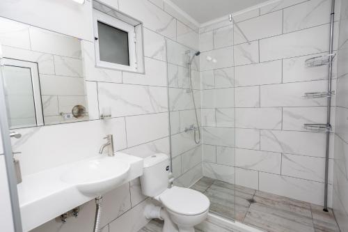 a bathroom with a toilet and a sink and a shower at Guest House Desi in Balchik