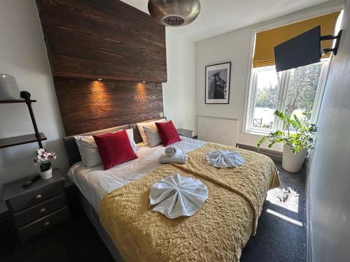 a bedroom with a bed with two towels on it at Green Corner Villa - Cosy Luxury in Central Torquay with Free Parking & EV in Torquay
