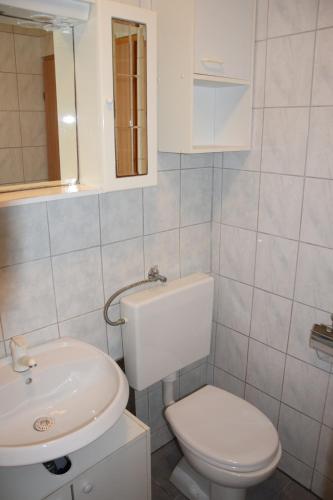 Łazienka z białą toaletą i umywalką w obiekcie Apartment Blanusa B w mieście Povljana