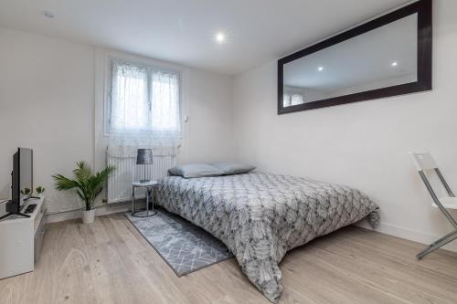 une chambre avec un lit et un miroir au mur dans l'établissement Loc Enjoy by Disneyland, à Jablines