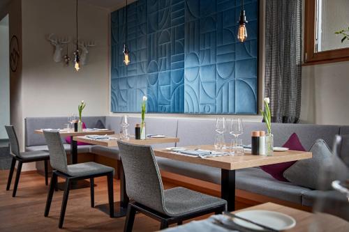 a restaurant with tables and chairs and a blue wall at Hotel Sonnblick in Lech am Arlberg