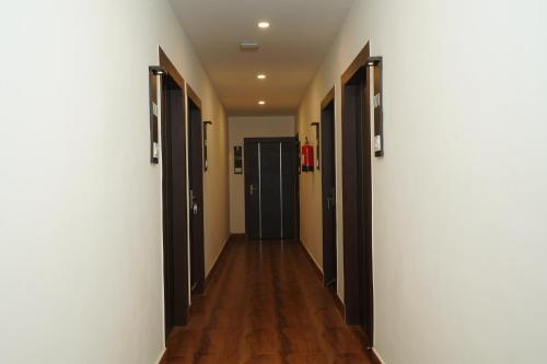 a hallway with a row of doors and wooden floors at Hotel Royal Palace in Guwahati