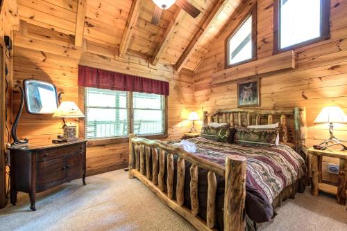 ein Schlafzimmer mit einem Bett in einem Blockhaus in der Unterkunft Fawn Cabin, 1 Bedroom, Sleeps 4, Hot Tub, Private, Pets, Gas Fireplace in Gatlinburg