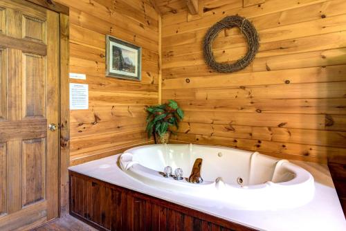 eine Badewanne in einem Zimmer mit einer Holzwand in der Unterkunft Fawn Cabin, 1 Bedroom, Sleeps 4, Hot Tub, Private, Pets, Gas Fireplace in Gatlinburg