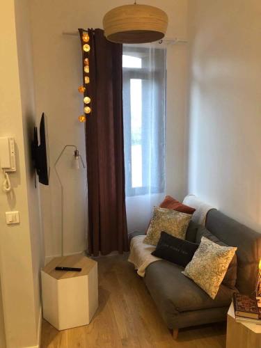 un salon avec un canapé et une fenêtre dans l'établissement L'appartement d'Eva, à Honfleur