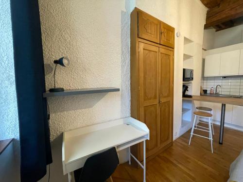 a white bench in a room with a kitchen at Studio vieille ville in Besançon