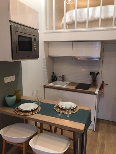 a kitchen with a table with two chairs and a microwave at L'appartement d'Eva in Honfleur