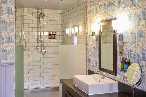 a bathroom with a sink and a shower and a mirror at Hotel Du Vin Poole in Poole