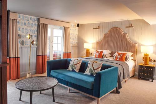 a hotel room with a bed and a blue couch at Hotel Du Vin Poole in Poole