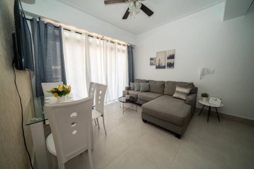 uma sala de estar com um sofá e uma mesa em Luxury 2 Br Naco Pool Gym Greatview em Santo Domingo