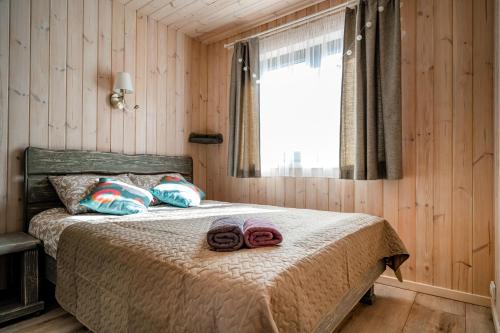 a bedroom with a bed with two towels on it at Jūras dzintars in Ainaži