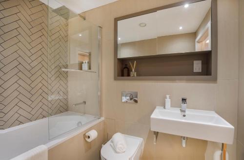 Apartment 21 Hudson Quarter Luxury Apartments في يورك: حمام مع حوض أبيض ومرحاض