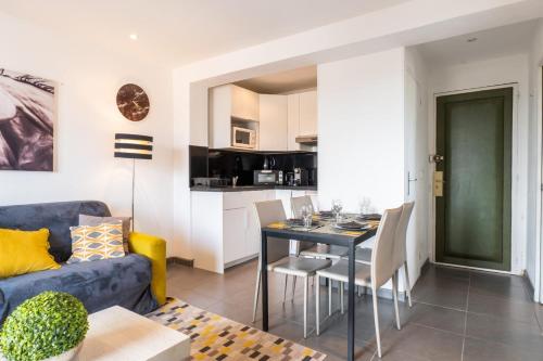 un salon avec un canapé bleu et une table dans l'établissement Apt With Balcony With Beach Vue, à Villeneuve-Loubet