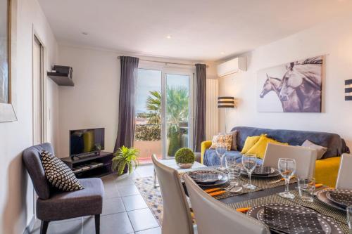 un salon avec une table à manger et un canapé dans l'établissement Apt With Balcony With Beach Vue, à Villeneuve-Loubet