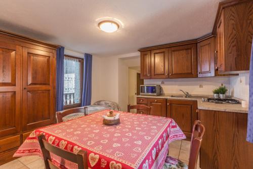 a kitchen with a table with a table cloth on it at L'Atelier du Temps - Clementine Appartements in Cogne