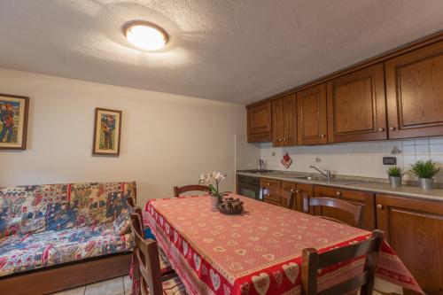 a kitchen with a table and a couch and a dining room at L'Atelier du Temps - Clementine Appartements in Cogne