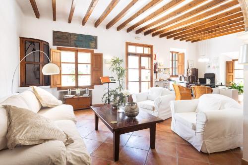 a living room with white couches and a table at Es Nord in Estellencs