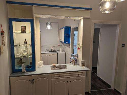 Cozy apartm.near Metro Ag.Marina في أثينا: مطبخ مع كونتر مع مرآة زرقاء