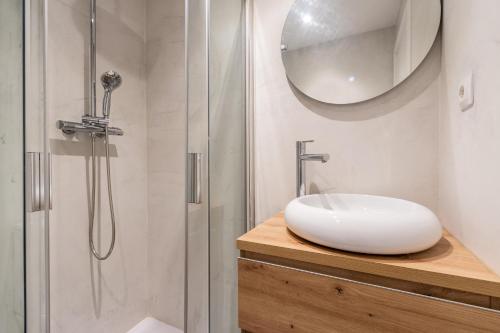 y baño blanco con lavabo y ducha. en Exclusive Apartments Barcelona 4 personas Torrella, en Terrassa
