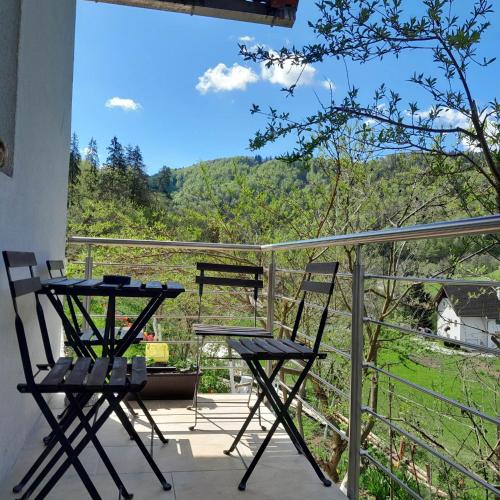 two chairs and a table on a balcony with a view at Nice Apartment near by Capital of Slovenia in Ljubljana