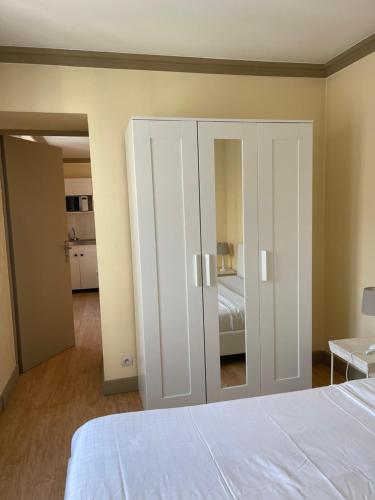 a bedroom with a bed and a mirrored cabinet at Appart Hotel Avril de la Roche in Angers