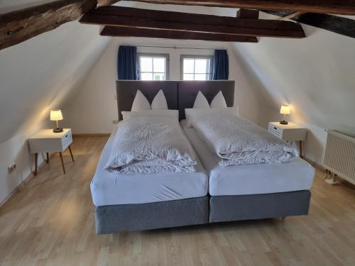 a bedroom with a large bed and two lamps at Ferienwohnungen im Gewölbe in Wismar