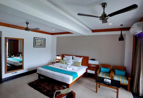 a bedroom with a bed and a mirror at Chandys Windy Woods Munnar in Munnar