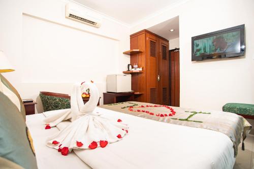 a room with two beds with a wedding dress on it at Silver Mounts Hotel in Phnom Penh