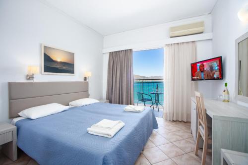 a hotel room with a bed and a desk and a table at Aristea Hotel in Elounda