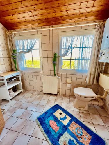 a bathroom with a toilet and a rug at Ferienwohnung direkt am Deich - Seerobbe - in Dornum