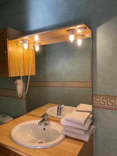 y baño con lavabo, espejo y toallas. en Appart Hotel Avril de la Roche, en Angers