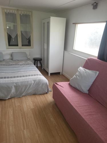 a bedroom with two beds and a couch at le bungalow au fond du jardin in Valeille