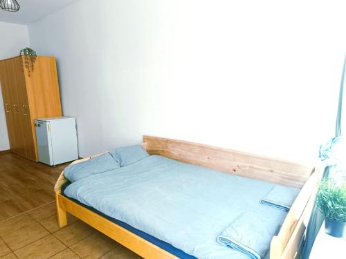 a bed with a wooden frame in a room at Przystań Tło dla Mew in Rydzewo
