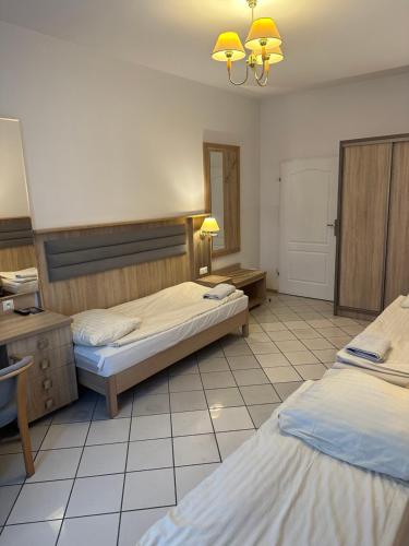 pokój hotelowy z dwoma łóżkami i lustrem w obiekcie Lotos w mieście Rawicz
