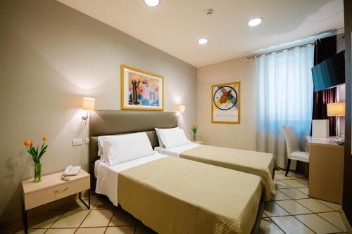 una habitación de hotel con 2 camas y una silla en Hotel Principe d'Aragona, en Módica