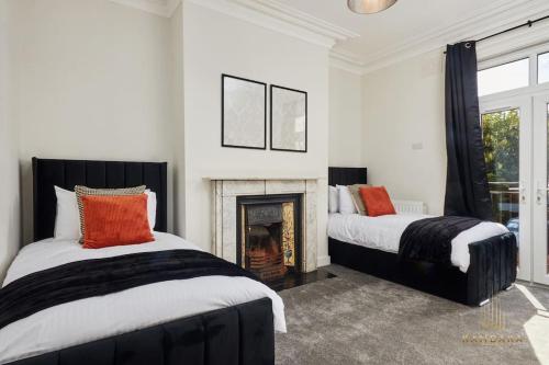 - 2 lits dans une chambre avec cheminée dans l'établissement Stunning 5Bed All En-suite Headingley Home, à Headingley