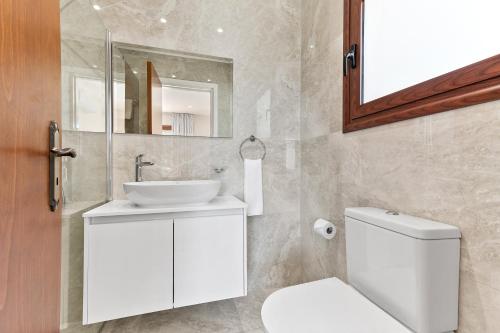 un bagno con un water bianco e un lavandino di Stunning 5 Bed Villa Calantha with Fantastic Outside Space - Aphrodite Hills a Kouklia