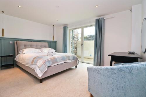 a bedroom with a bed and a couch at BY THE BEACH, The Quies, Beach House in St Merryn