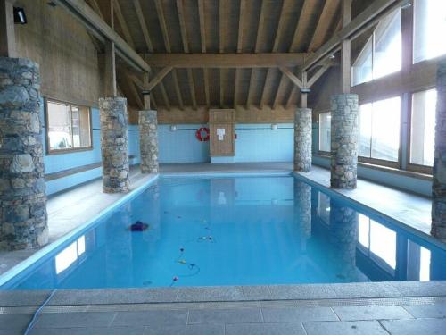 une grande piscine avec de l'eau bleue dans un immeuble dans l'établissement Appartement cosy avec piscine - 4 pers, balcon, parking - près des Saisies - FR-1-594-156, à Villard-sur-Doron