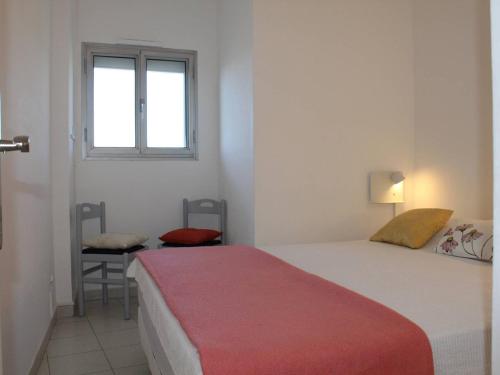 une chambre avec un lit, une fenêtre et une chaise dans l'établissement Appartement 3 Pièces, 6 Couchages, Climatisation, Terrasse Vue Mer, Parking - FR-1-252A-55, à Villeneuve-Loubet