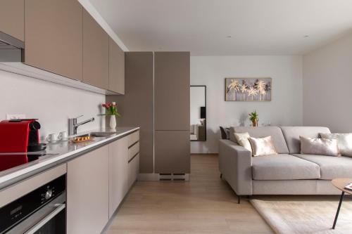 a kitchen and a living room with a couch at Lugano Superior Suites - Free Parking in Lugano