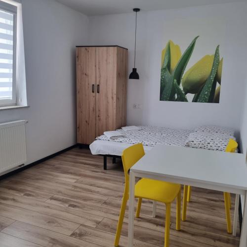 a room with two beds and a table and chairs at Figaro Apartaments in Gdynia