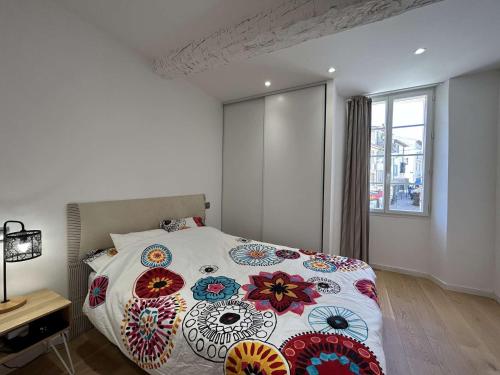 - une chambre avec un lit avec une couette à fleurs et une fenêtre dans l'établissement Appartement 3 Pièces Climatisé au Cœur de Sainte-Maxime, à 100m des Plages - FR-1-226-513, à Sainte-Maxime