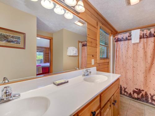 ein Badezimmer mit zwei Waschbecken und einem großen Spiegel in der Unterkunft Eagles Point Lodge, 4 Bedrooms, Sleeps 16, View, Pool Access, Game Room in Gatlinburg