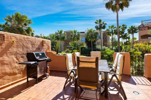 - une terrasse avec barbecue, chaises et barbecue dans l'établissement Beautifull penthouse, BIG solarium with seaview and exotic oasis gardens, à Estepona