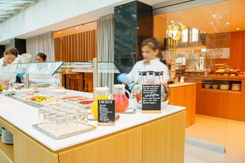 a woman standing at a counter in a restaurant at Hotel Wettstein in Basel