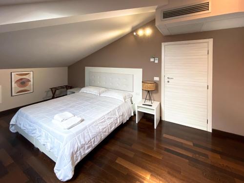 um quarto com uma grande cama branca e uma porta em Le Stanze di Gianmarmo - Via di Mezzo em Mirandola